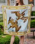 Person holding a large scarf with pelican design outdoors
