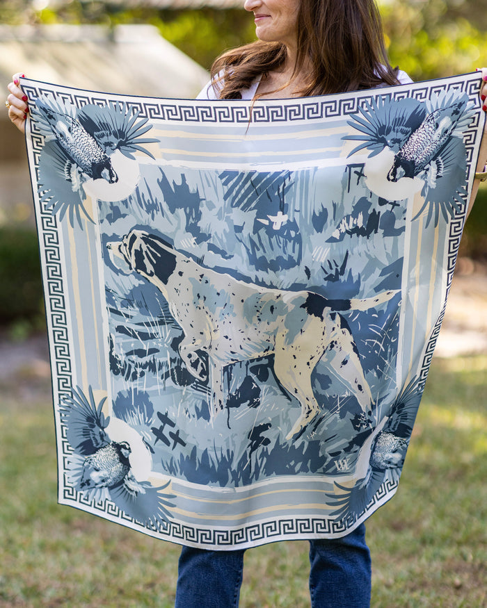 Person holding a large scarf with hunting dog and quail outdoors