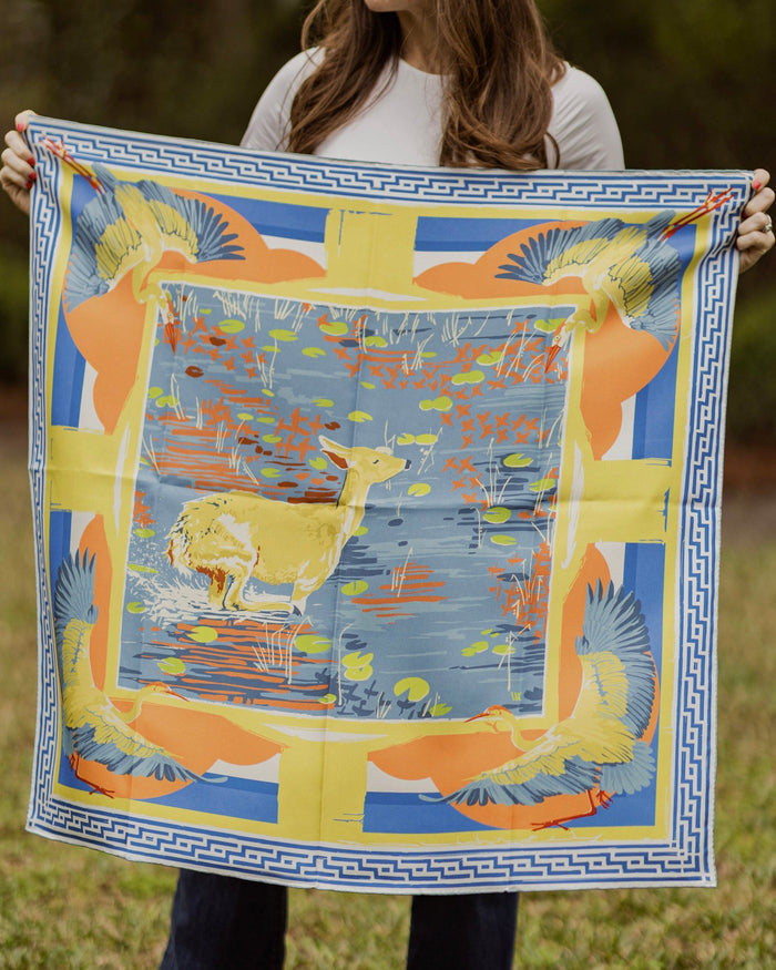 Person holding a colorful scarf with deer design outdoors