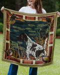 A woman holds up a square silk scarf featuring a hunting dog, birds, and a decorative border.