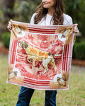 woman holding a wine colored silk scarf with a bird dog and quail design